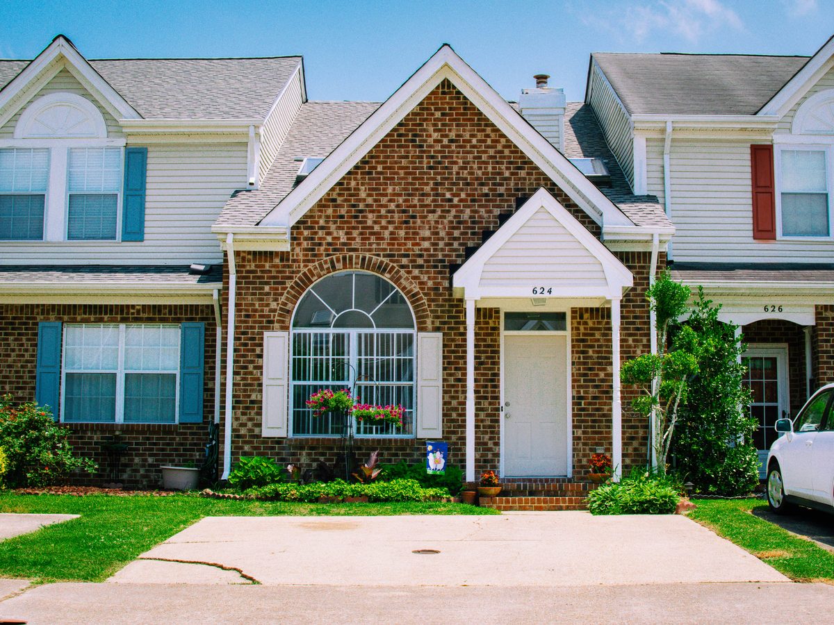Brick townhome rental property with curb appeal — flower boxes, manicured landscaping