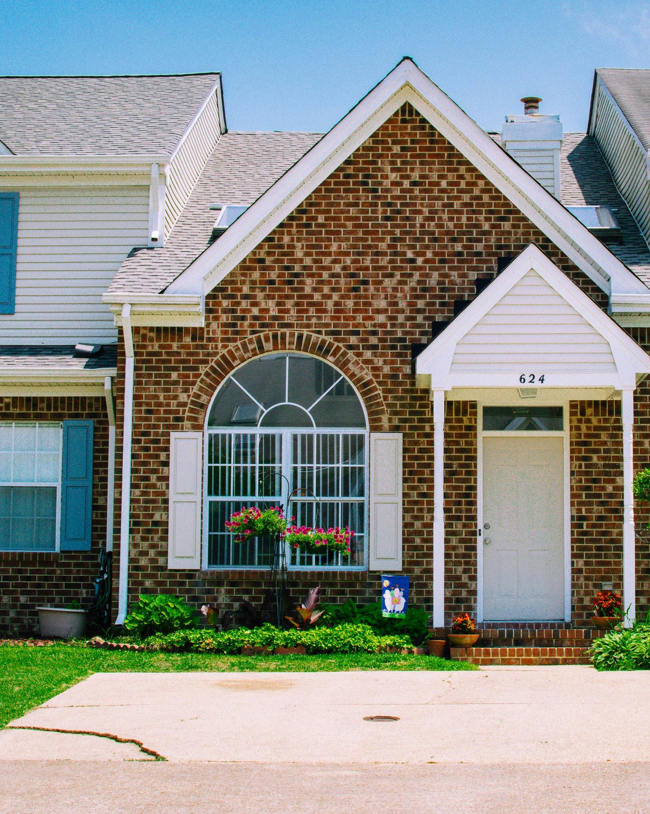 Brick townhome rental property with curb appeal — flower boxes, manicured landscaping